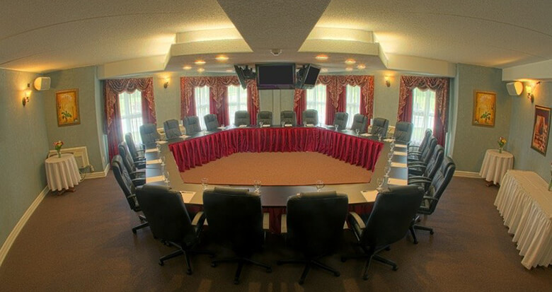 Cedar Meadows Spa & Resort A conference room at a resort in Timmins, Ontario, with a circular table and chairs. - Timmins, Ontario