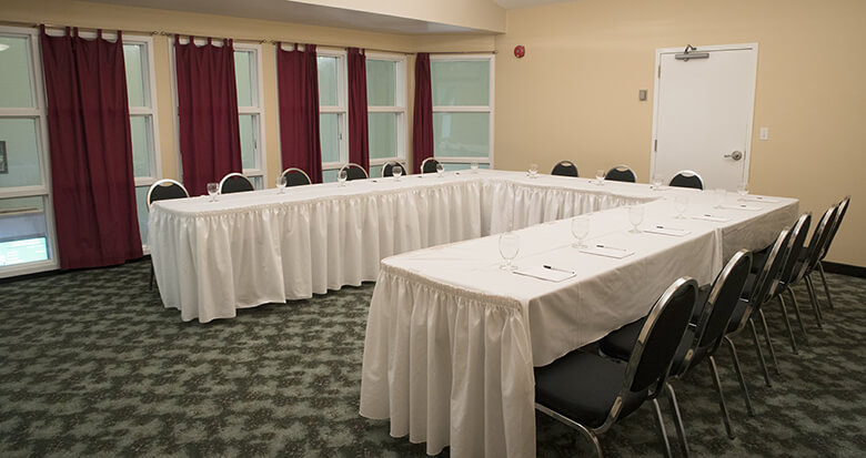Cedar Meadows Spa & Resort A meeting room at Cedar Meadows Resort & Spa with a long table and chairs. - Timmins, Ontario