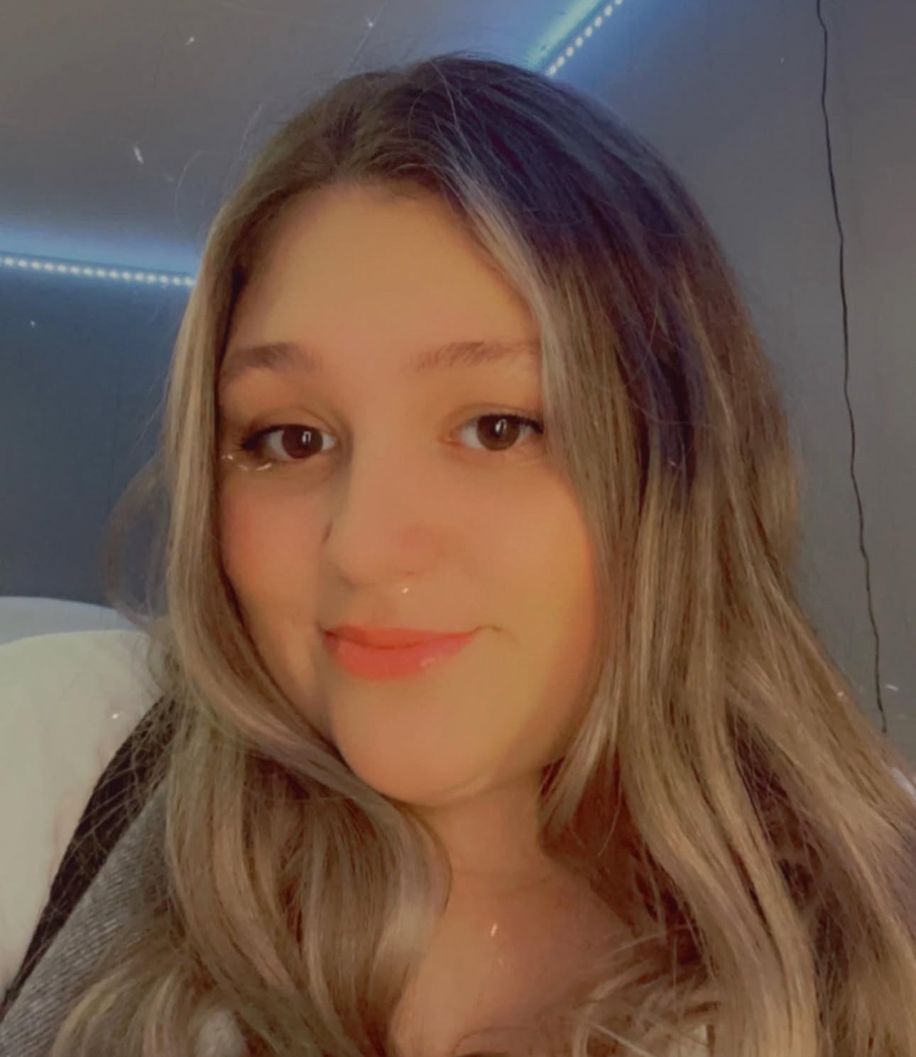 Cedar Meadows Spa & Resort A young woman with long, wavy blonde hair smiles at the camera in a room with blue LED strip lights on the ceiling. - Timmins, Ontario